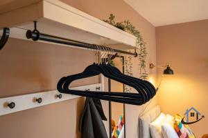 einem Schrank mit einem Kleiderständer mit Mänteln und einer Lampe in der Unterkunft Minchin House, nr Npton Saints Rugby, sleeps 8 in Dallington