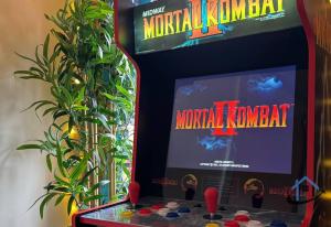 eine Videospielmaschine mit einem Spielbrett und einer Pflanze in der Unterkunft Minchin House, nr Npton Saints Rugby, sleeps 8 in Dallington