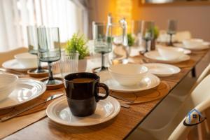 uma mesa de madeira com pratos e uma chávena de café em Minchin House, King beds workspace corporates parking sleeps 8 em Dallington
