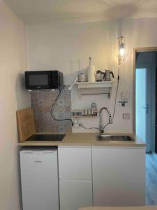 a small kitchen with a sink and a microwave at Charming Studio to Venelles 10 minutes from Aix in Venelles