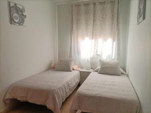 two beds in a room with a window at Casa Nana - Playa Santiago in Playa de Santiago