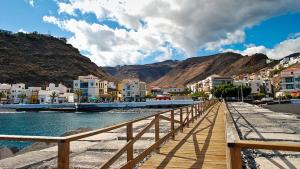 a wooden walkway next to a body of water with buildings at Casa Nana - Playa Santiago in Playa de Santiago