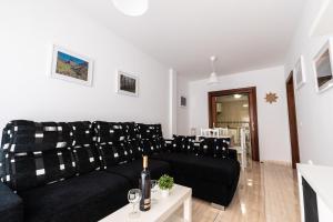 a living room with a black couch and a table at Casa Nana - Playa Santiago in Playa de Santiago