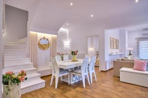een eetkamer en een woonkamer met een tafel en stoelen bij Elena Luxury Suite Agios Stefanos in Agios Stefanos