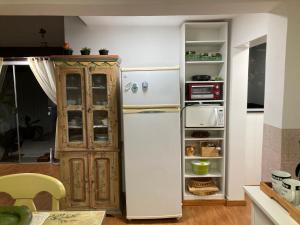 a kitchen with a white refrigerator and a cabinet at Loft no Retiro in Brumadinho