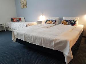 1 dormitorio con 1 cama blanca grande con almohadas en Frühstückpension Larson en Bad Hofgastein