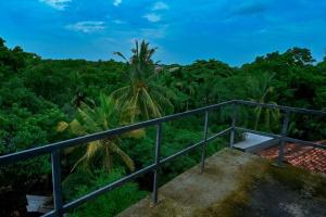 balcón con vistas a un bosque en Emerald Home Stay, en Anuradhapura
