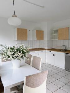 a kitchen with a white table with flowers on it at Haus Neuss-1.OG in Neuss