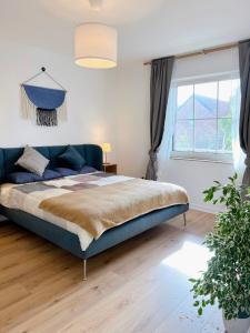 Un dormitorio con una cama azul y una ventana en Haus Neuss-1.OG, en Neuss