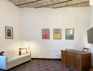 a living room with a couch and paintings on the wall at RomeAsYouLike - Vatican Apartment N°73 in Rome
