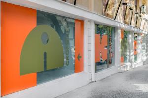 a store front with an orange and green window display at Cabins Sleeping Mets in Athens