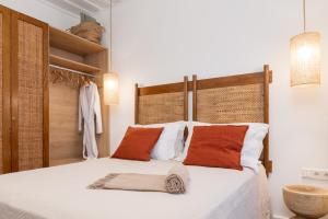 a bedroom with a bed with orange and white pillows at Keepos by Polykratis in Kokkari