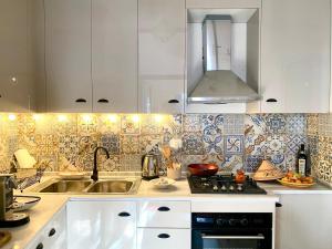 a kitchen with white cabinets and a sink at Cosy home in Sidi Bou Said in Sidi Bou Saïd