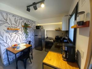 małą kuchnię z małym stołem oraz kuchnię z kuchnią w obiekcie Joli Apartments - Studio B - 2 pax en el corazón de la ciudad w mieście San Martín de los Andes