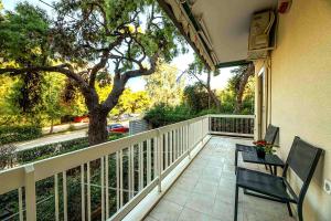 - un balcon avec deux chaises et un arbre dans l'établissement Boutique77 Luxury Apartment, à Athènes
