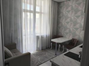 a living room with a couch and a table and a window at ЖК Бухар Жырау in Astana