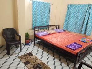 1 dormitorio con 1 cama y 1 silla en Ghosh homestay, en Calcuta