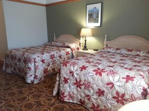 A bed or beds in a room at Granite Town Hotel