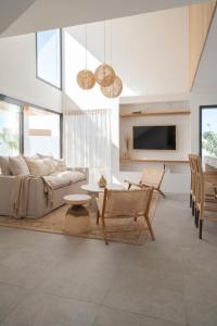 un soggiorno con divano e tavolo di Villa NOMA - Design space with Pool in Corralejo a Corralejo