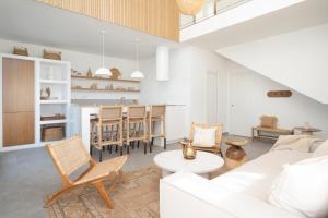 Villa NOMA - Design space with Pool in Corralejo في كوراليخو: غرفة معيشة مع أريكة بيضاء وكراسي