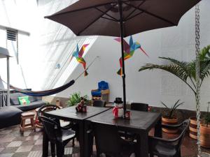 a table with an umbrella in a room at Absolute Hotel & Hostel Boutique in Medellín