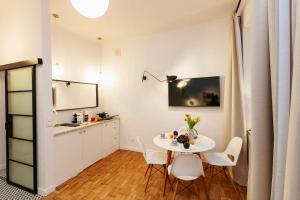 a dining room with a white table and chairs at Charming apartment next to the Old Town! in Warsaw