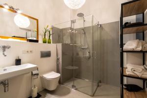 a bathroom with a shower and a toilet and a sink at BARONHAUS Aparthotel & Suites in Passau