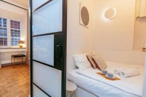 um pequeno quarto com uma cama e uma parede de vidro em Charming apartment next to the Old Town! em Varsóvia