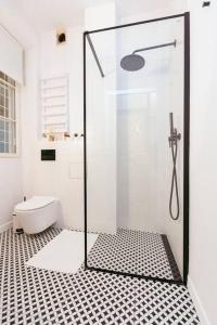 uma casa de banho com uma cabina de duche em vidro e um WC. em Charming apartment next to the Old Town! em Varsóvia