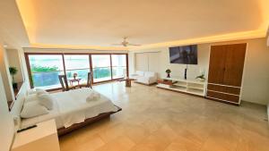 a large bedroom with a bed and a large window at Villa Azul Maya in Isla Mujeres