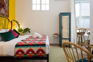 um quarto com uma cama com um cobertor colorido em Boho 03 Bohemian Studio in Mar Mikhael Eartha em Beirute