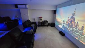 una sala de estar con una pantalla grande en una habitación en Villa Azul Maya, en Isla Mujeres