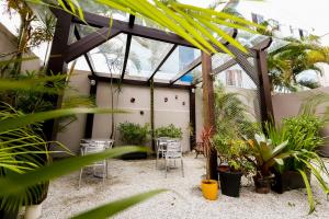 un patio con sillas y plantas en un invernadero en Das Nações Hotel, en Florianópolis