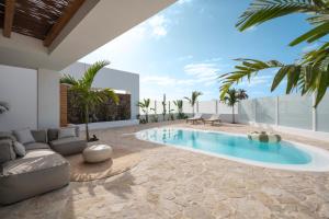 a living room with a swimming pool and a villa at Villa NOMA - Design space with Pool in Corralejo in Corralejo