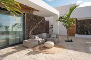 ein Wohnzimmer mit einem Sofa und einem Tisch in der Unterkunft Villa NOMA - Design space with Pool in Corralejo in Corralejo