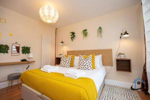 ein Schlafzimmer mit einem großen Bett mit gelber Bettwäsche in der Unterkunft Sandby House, King beds workspace corporates parking sleeps 10 in Nottingham