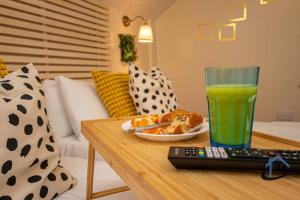 a table with a remote control and a glass of juice at Sandby House, King beds workspace corporates parking sleeps 10 in Nottingham
