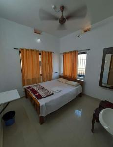 1 dormitorio con 1 cama grande y lavamanos en Aikya homestay, en Gokarna