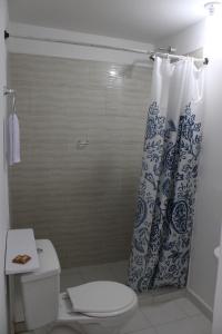 y baño con aseo y cortina de ducha. en Absolute Hotel & Hostel Boutique, en Medellín