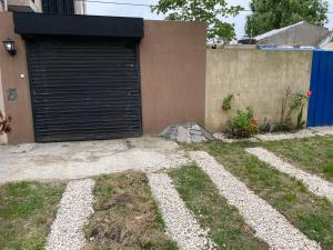 uma porta de garagem ao lado de uma casa em Monoambiente para 3 em Santa Teresita