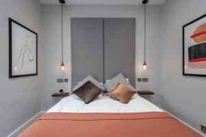 1 dormitorio con 1 cama con 2 almohadas en Luxury Georgian House in Marylebone: Modern 1-Bed Retreat, en Londres