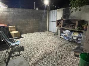 eine Terrasse in der Nacht mit einem Kamin und einem Stuhl in der Unterkunft Monoambiente para 3 in Santa Teresita