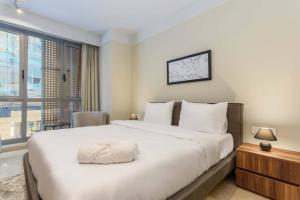 Un dormitorio con una gran cama blanca y una ventana en Solidere Tune 1Bedroom Apartment At Kantari Beirut en Beirut