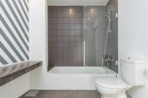 a bathroom with a toilet and a shower and a tub at The Club 1-Bedroom Apartment in Gemmayze in Beirut