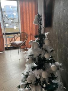 un arbre de Noël dans une pièce avec une chaise dans l'établissement Perpignan Vauban magnifique T2 avec balcon, à Perpignan