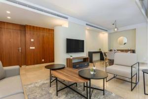 Solidere Tune 1Bedroom Apartment At Kantari Beirut في بيروت: غرفة معيشة مع أريكة وتلفزيون