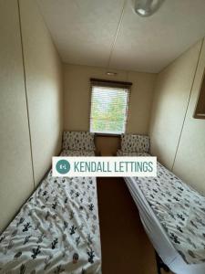 a small bedroom with a bed with kennel settings at Stoke Clump (Green Lawns) in Selsey