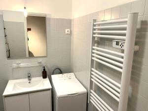 a white bathroom with a sink and a mirror at Cannes center wifi AC 100 m from sea and sand beach in Cannes