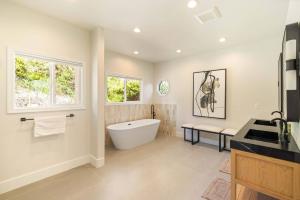 bagno con vasca, finestra e lavandino di Sycamore View Villa I a Los Angeles