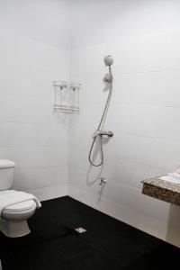 a white bathroom with a shower and a toilet at Kanda Boutique in Patong Beach